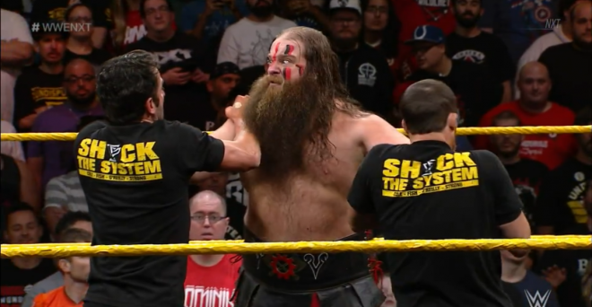 War Raider Hanson scowls at Roderick Strong and Kyle O'Reilly as he holds both of them by the neck on January 9th's nXt show.