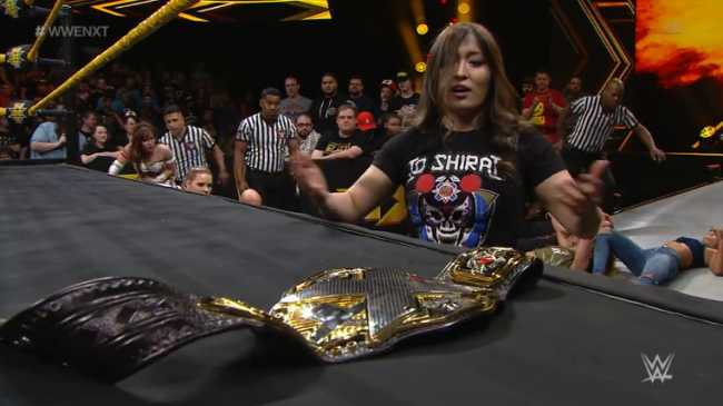 Shirai eyes the Women's Championship sitting on the ring apron after a major brawl in the Women's Division on nXt TV.